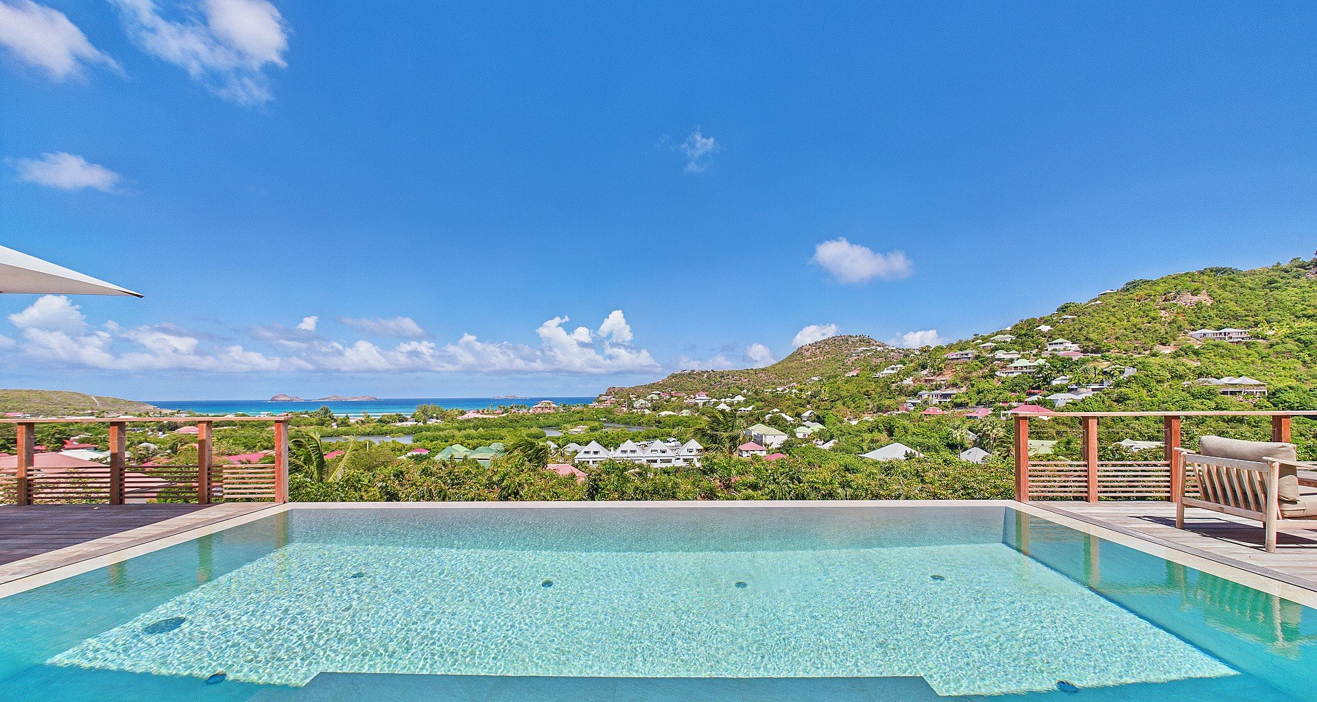 Infinity pool overlooking ocean with hills in background at Villa Bonnie, St. Jean